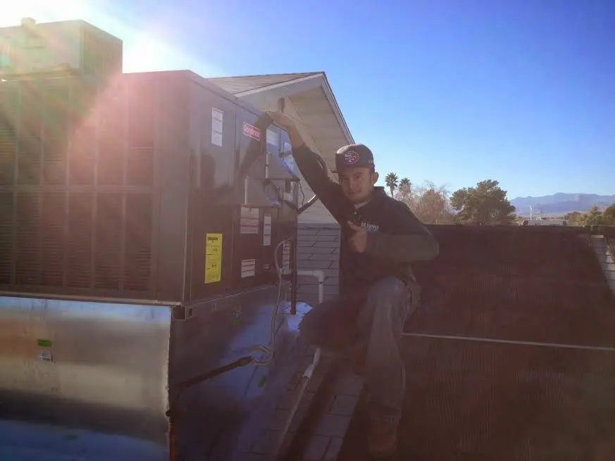HVAC technician performing AC Tune-Up on a rooftop unit in Hillsborough